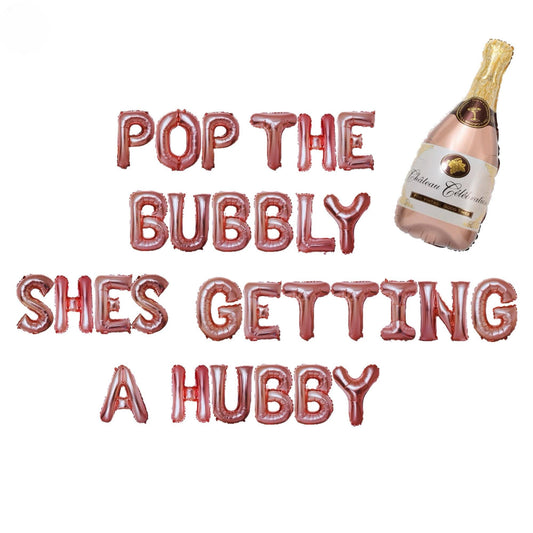 a bottle of champagne and a balloon that says pop the bubbly she&#39;s