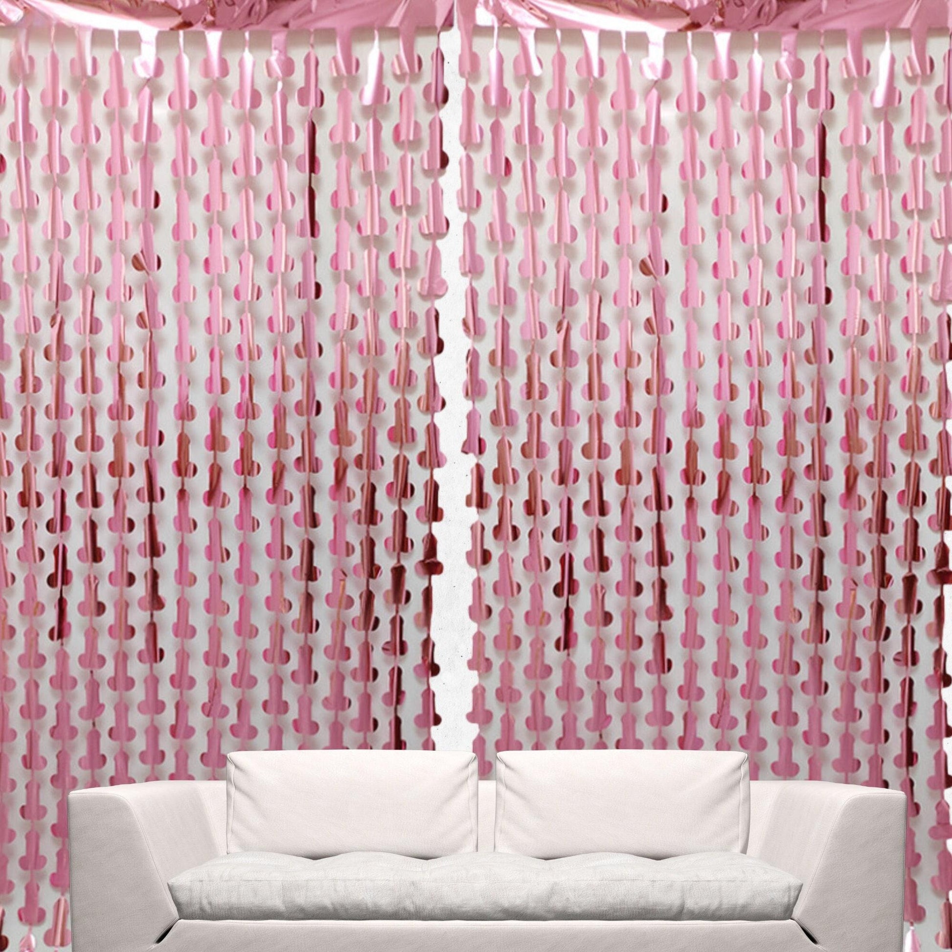 a white couch sitting in front of a pink curtain