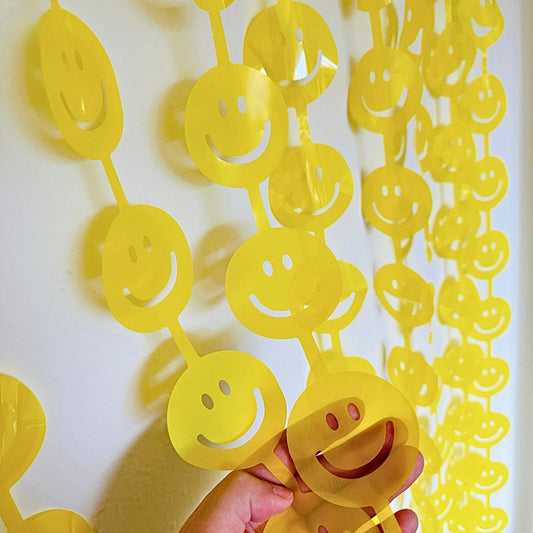 a hand holding a yellow smiley face cut out of paper