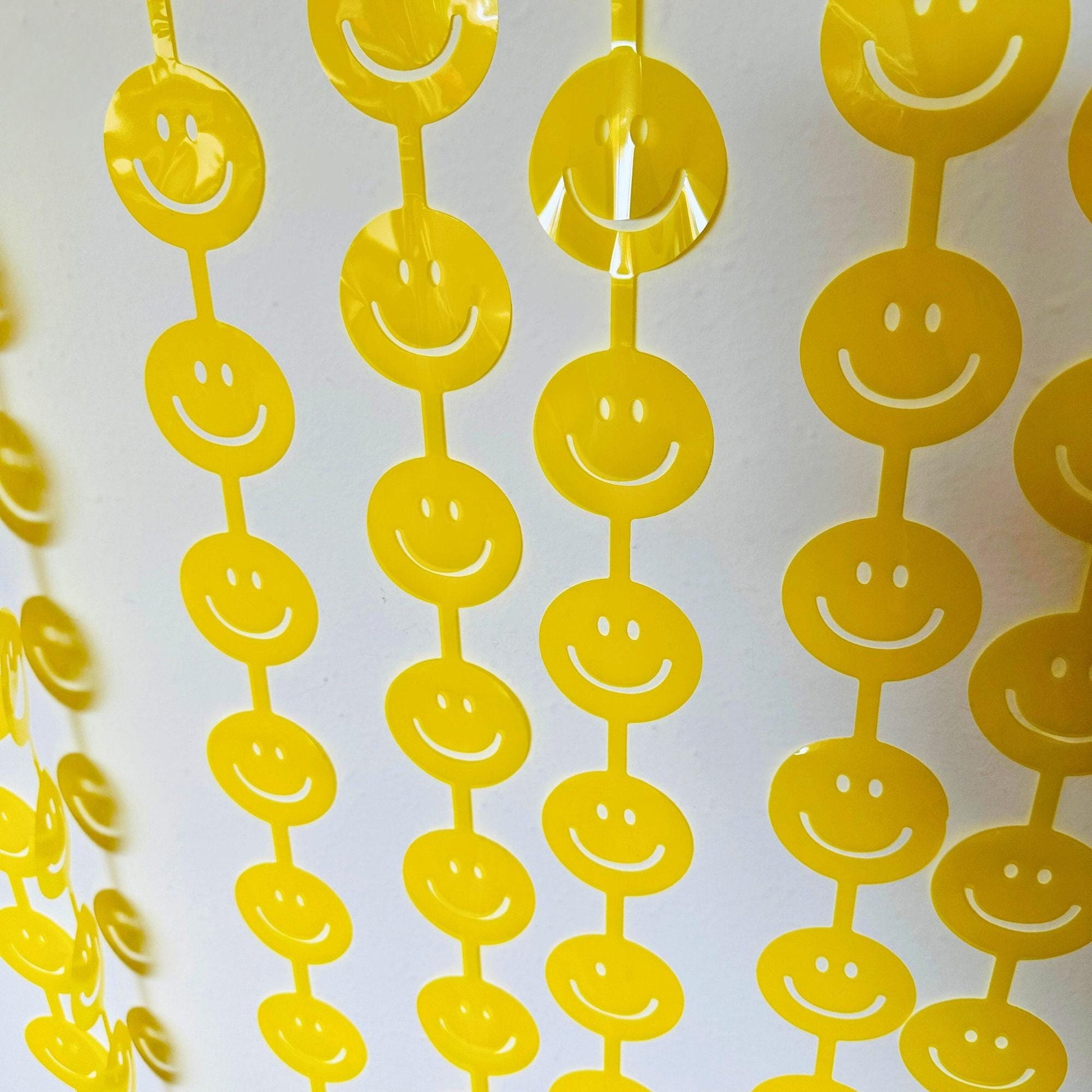 a group of yellow smiley faces hanging from strings